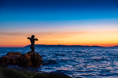 Statue of the Mermaid in Podgora at Sunset
